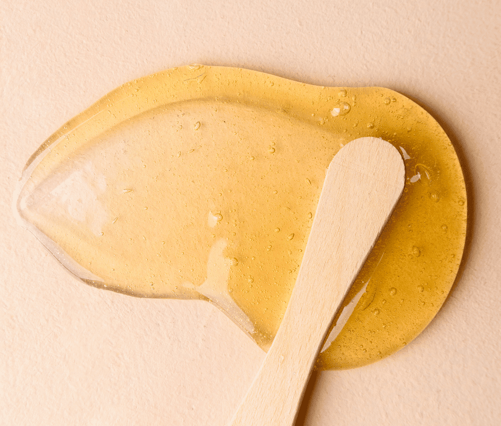 Wooden spoon resting on a blob of honey.